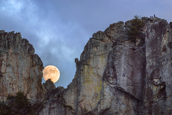Photo of the full moon rising through the gunsight notch in Seneca Rocks, West Virginia by Jesse Thornton.