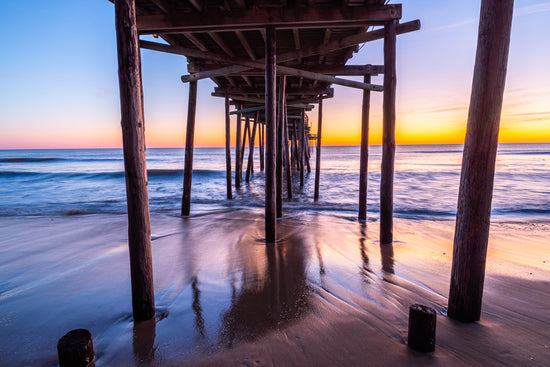 Long Exposure at dawn under the Outer Banks Fishing Pier with the waves moving out in North Carolina