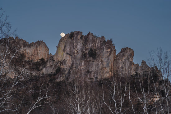 Wide angle view of the full moon rising above Seneca Rocks in West Virginia.